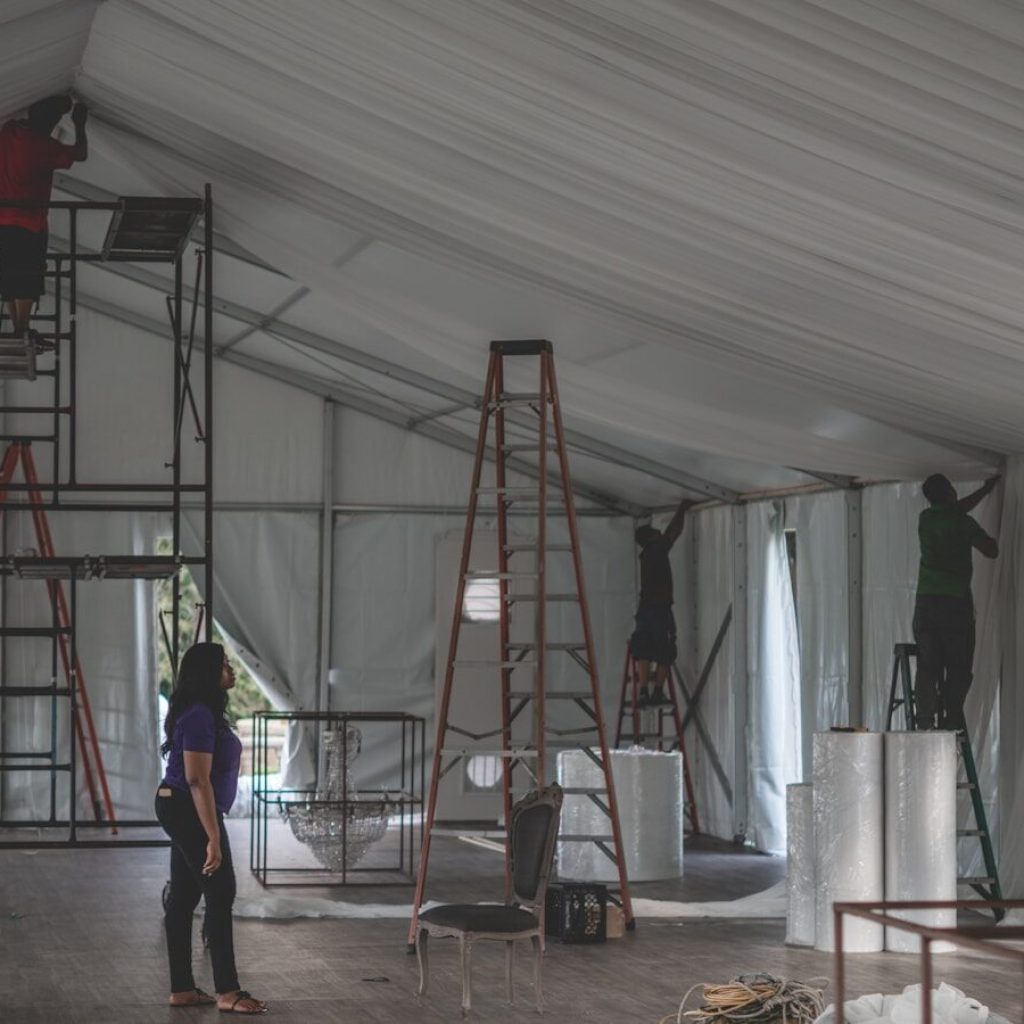 woman supervising a group of men decorating